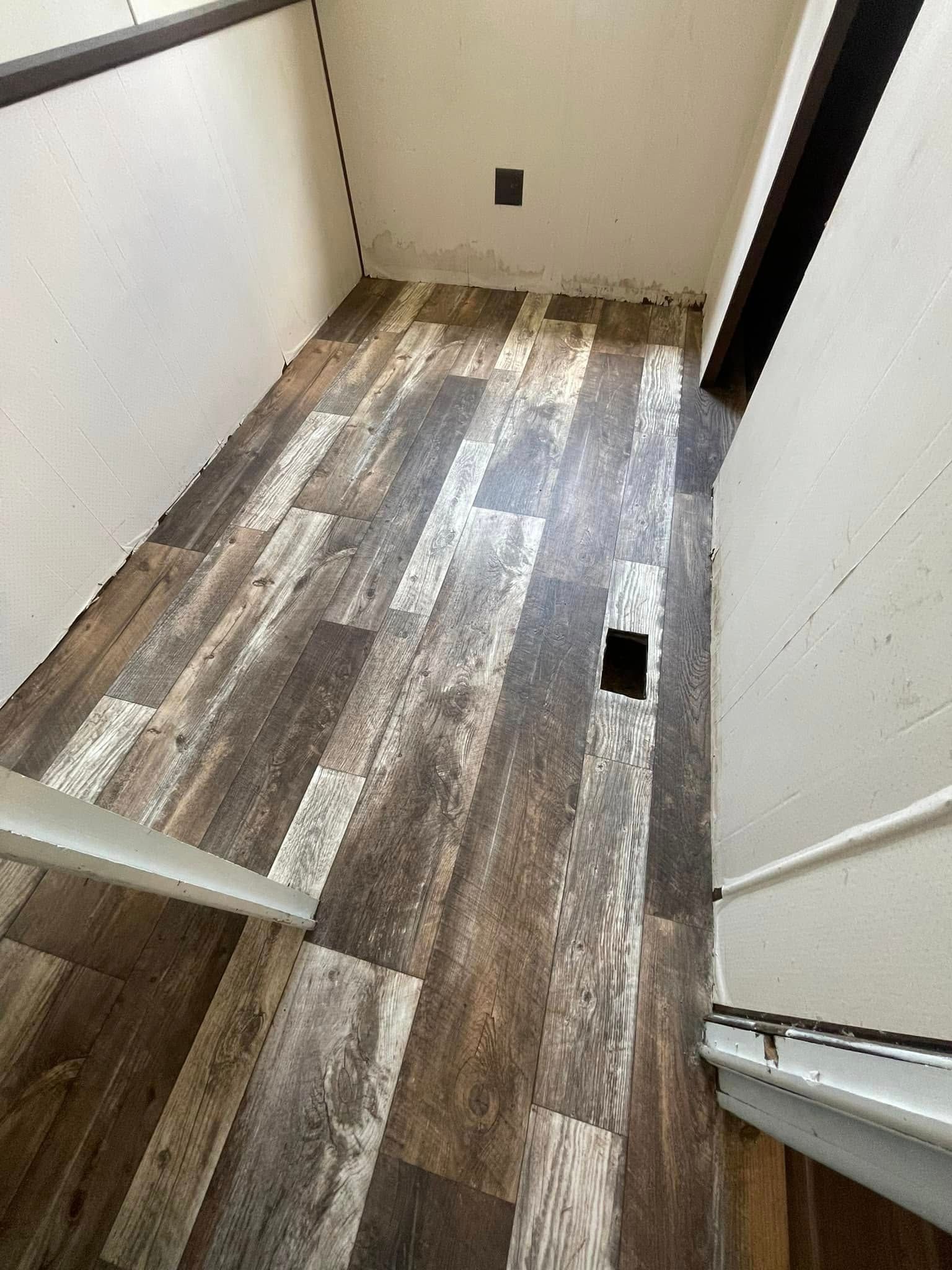 Narrow room with wood-look flooring. White walls and trim with dark frame.