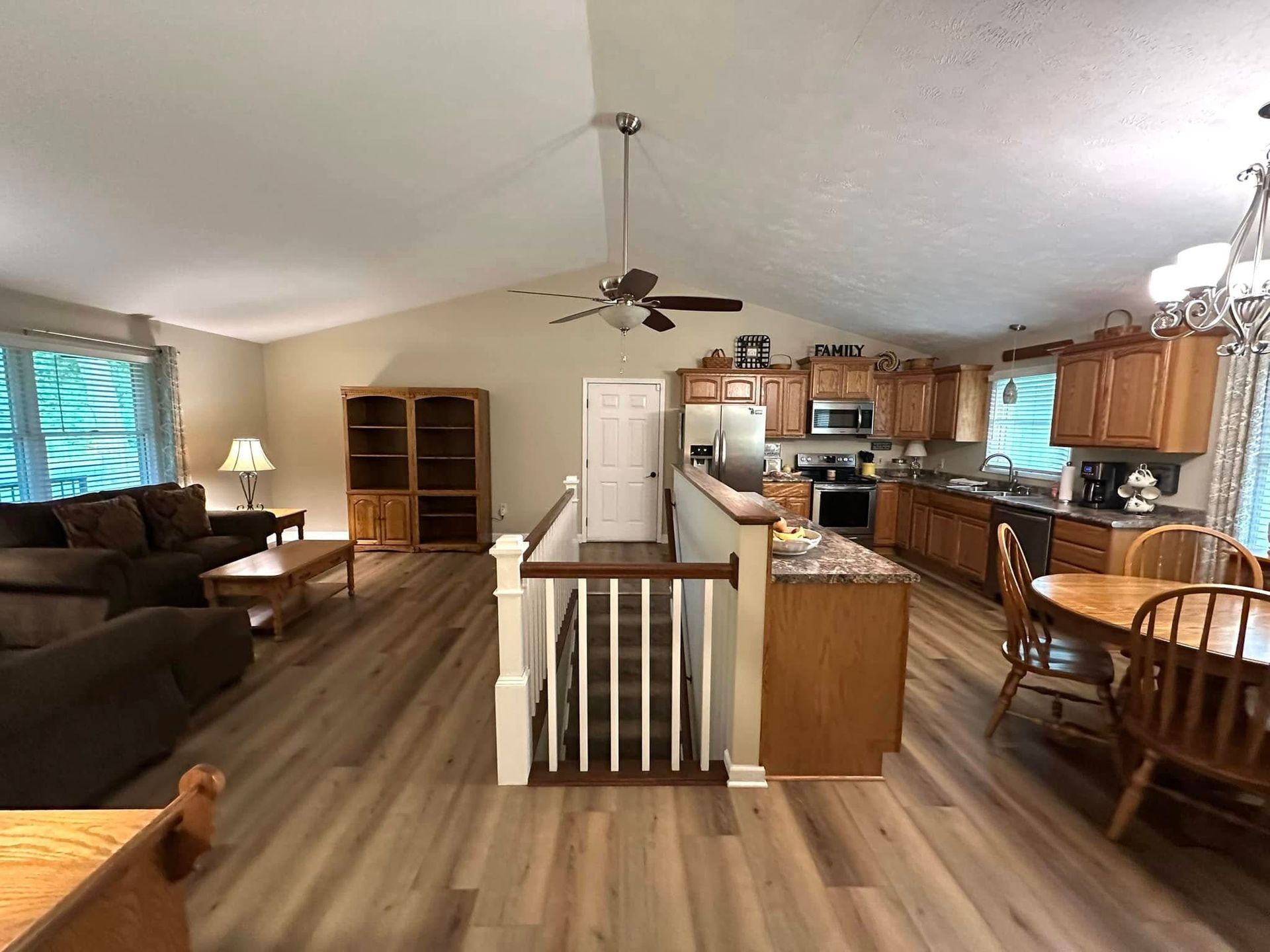 Open-concept living space with kitchen, dining area, and living room; light wood floors and cabinets.