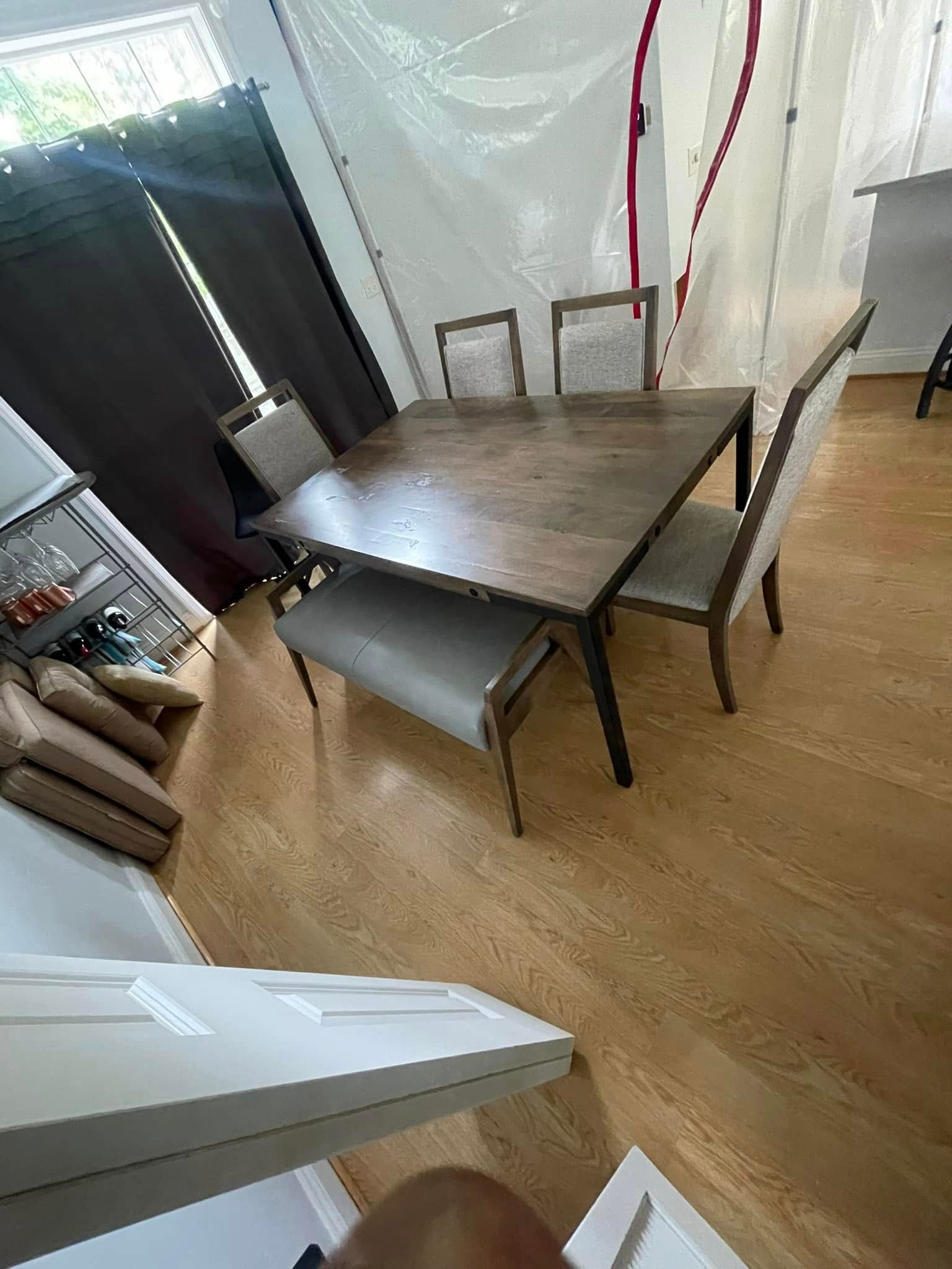 Dining table with four chairs and bench on wood floor.