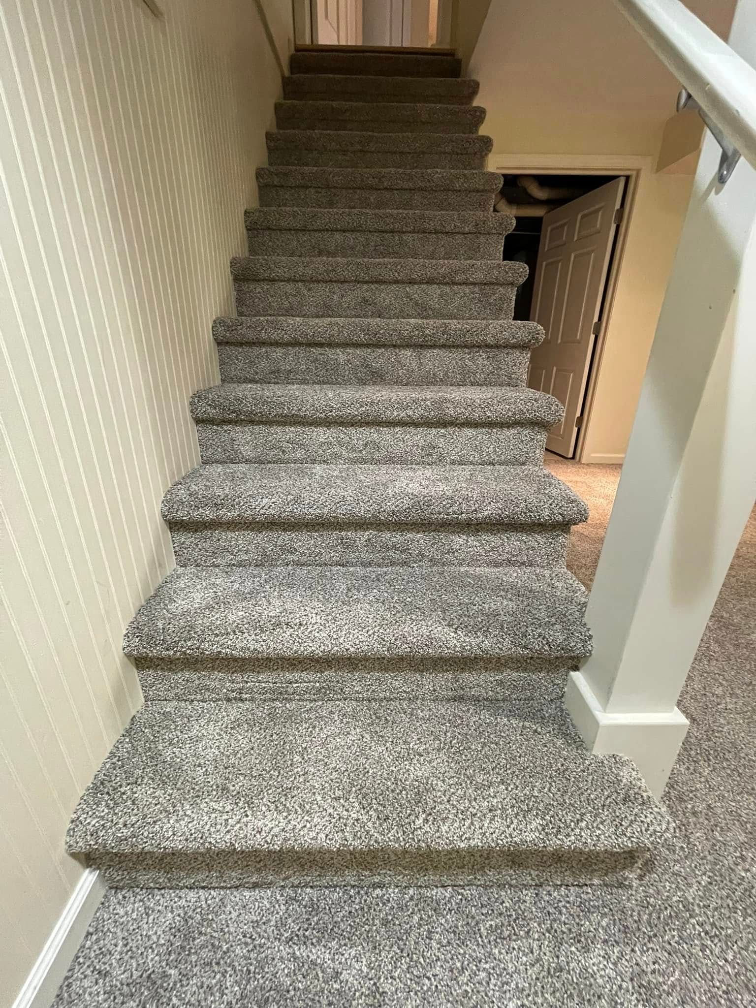 Carpeted staircase with light gray and white speckled pattern, leading upward.