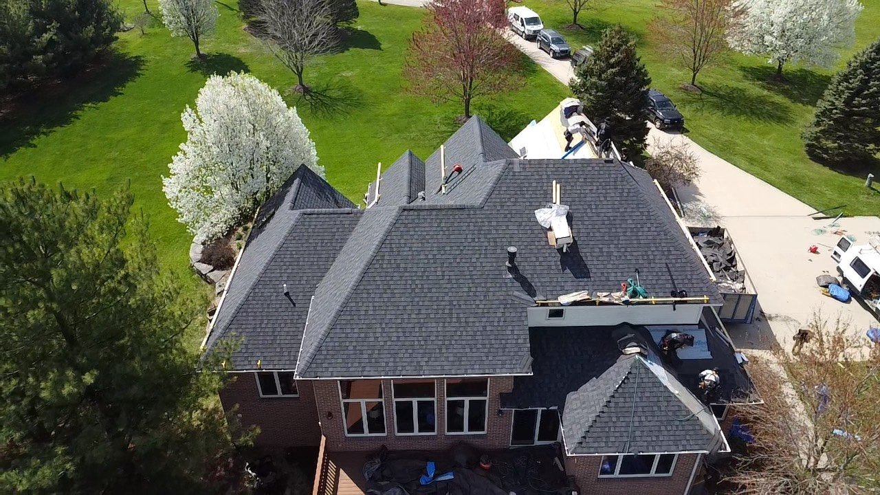 An aerial view of a house with a new roof being installed.