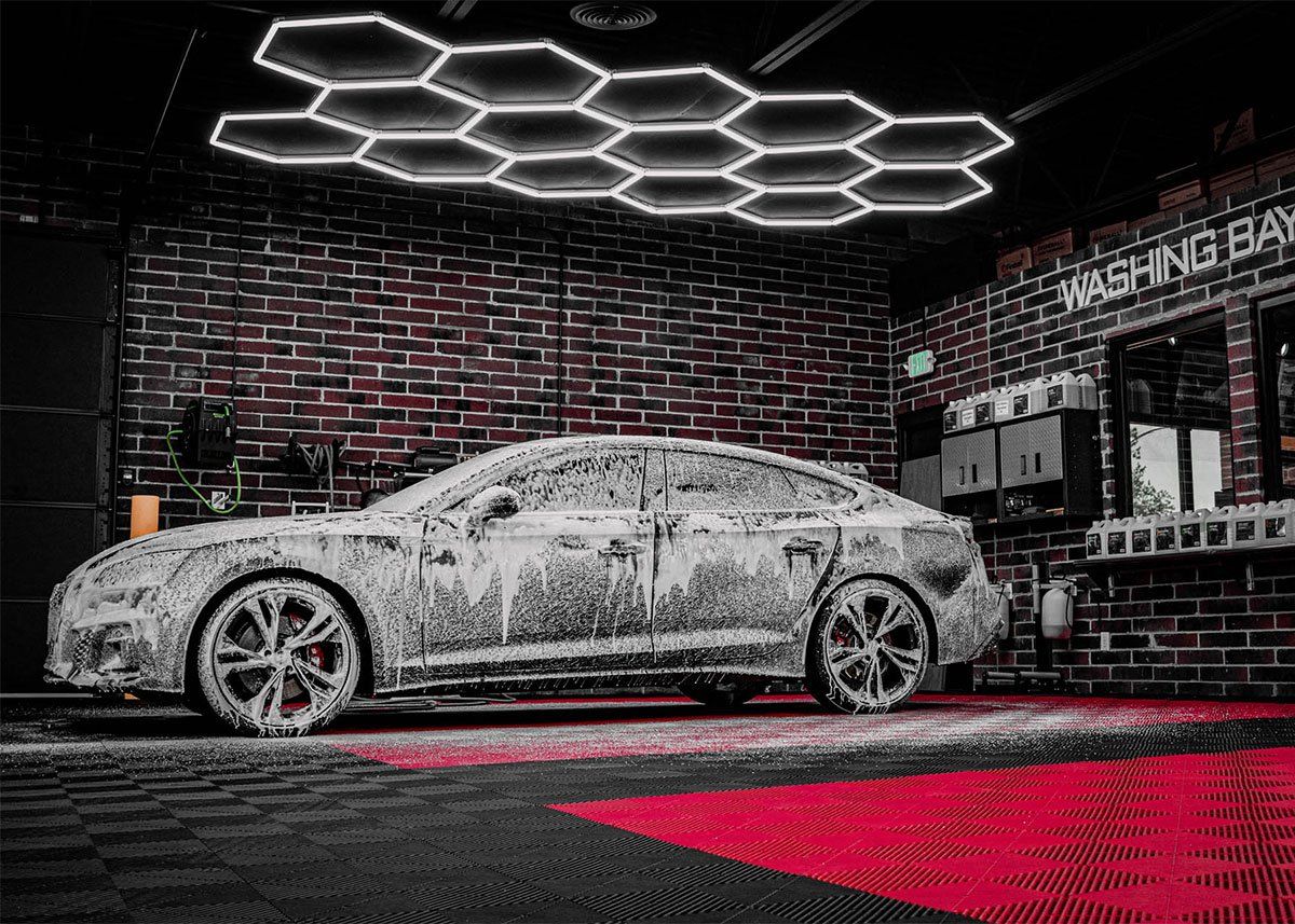 A car is covered in foam in a car wash.