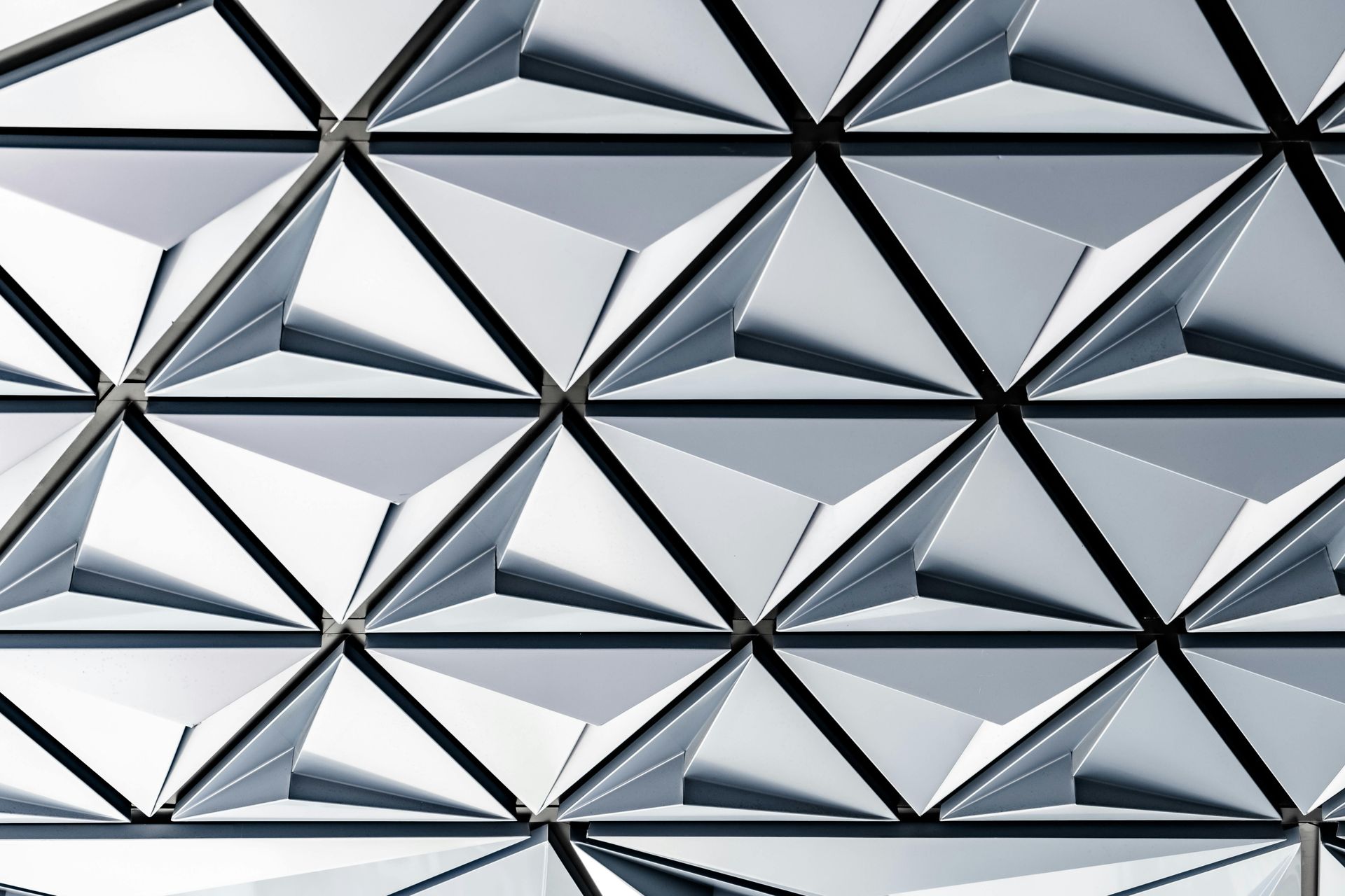 Geometric pattern of gray triangular panels, creating a textured surface.