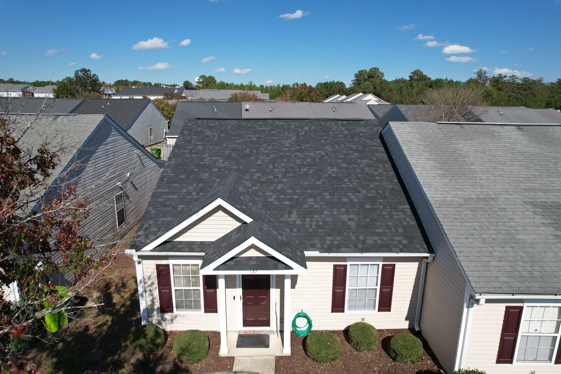 An aerial view of a house with a black roof