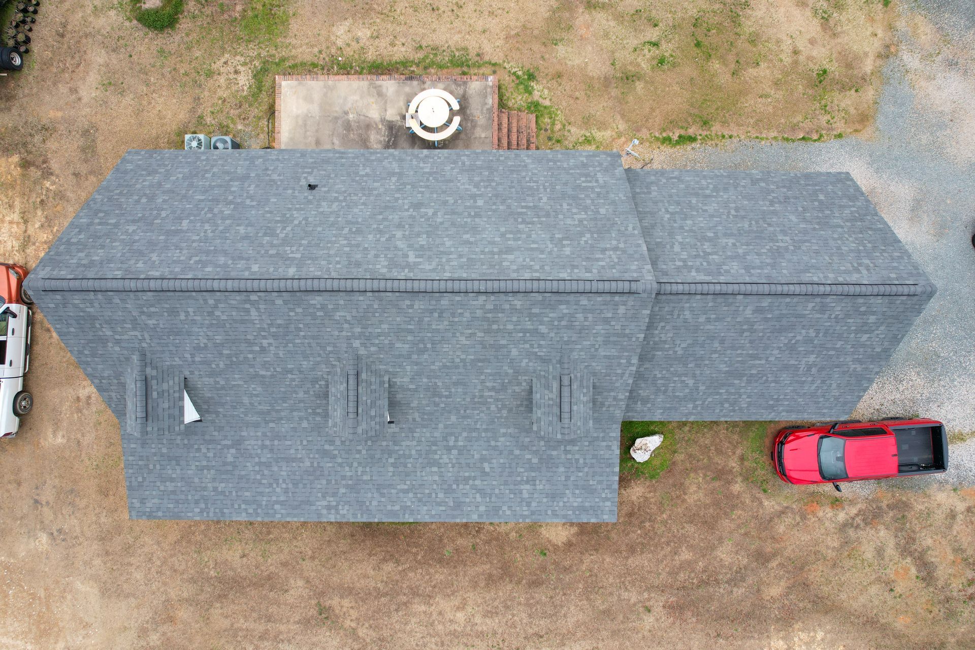 two men are standing on top of roof next to a chimney.