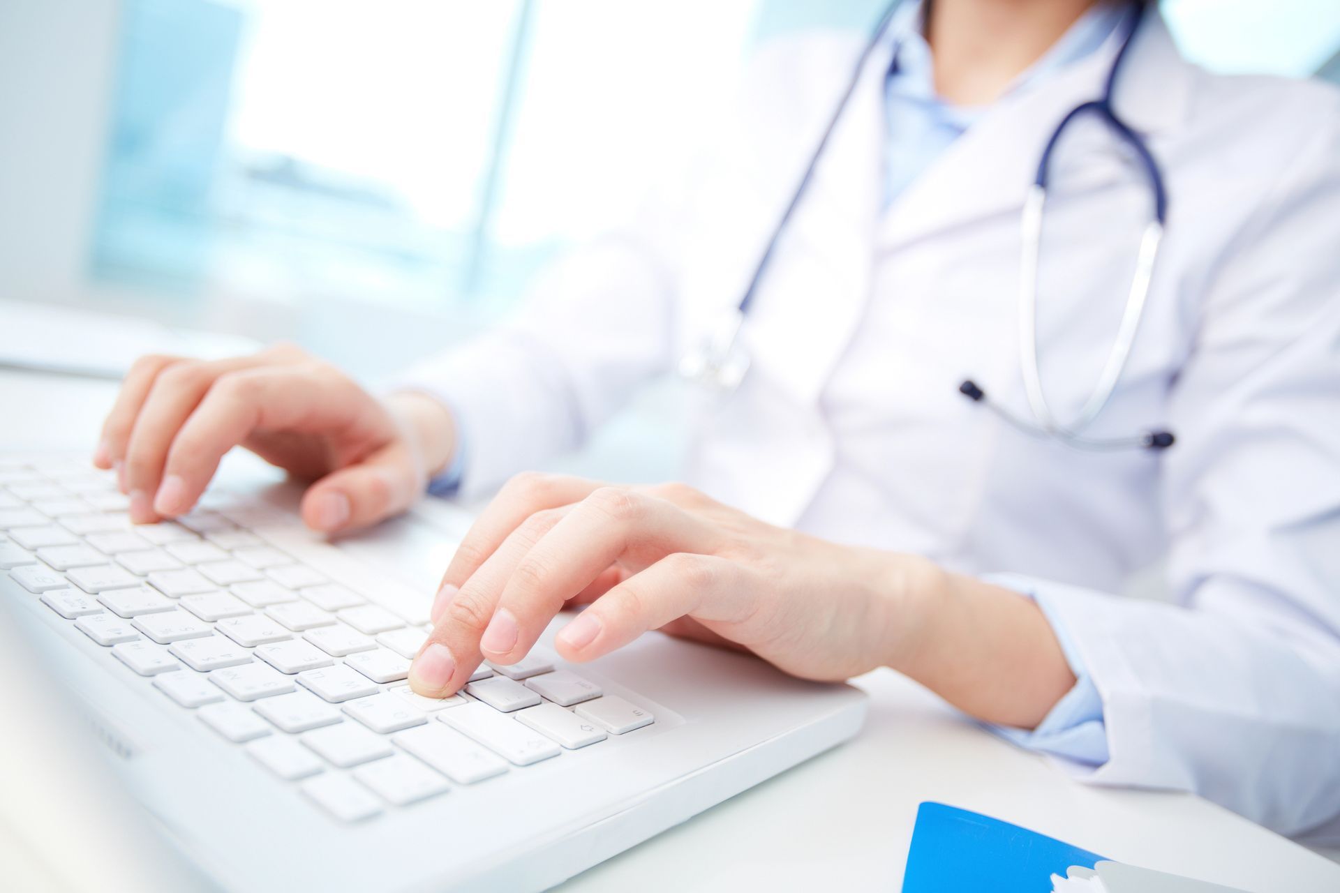 Un médico está escribiendo en un teclado de computadora.