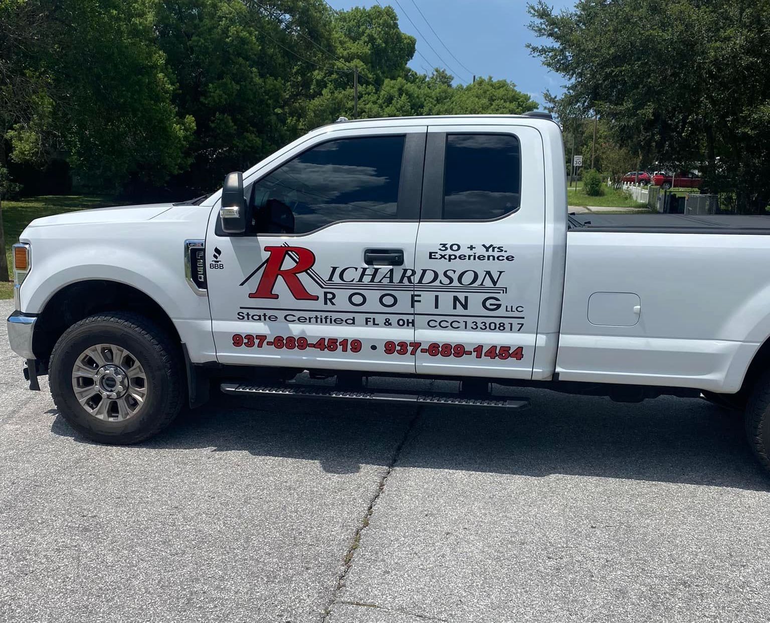 A white richardson roofing truck is parked on the side of the road