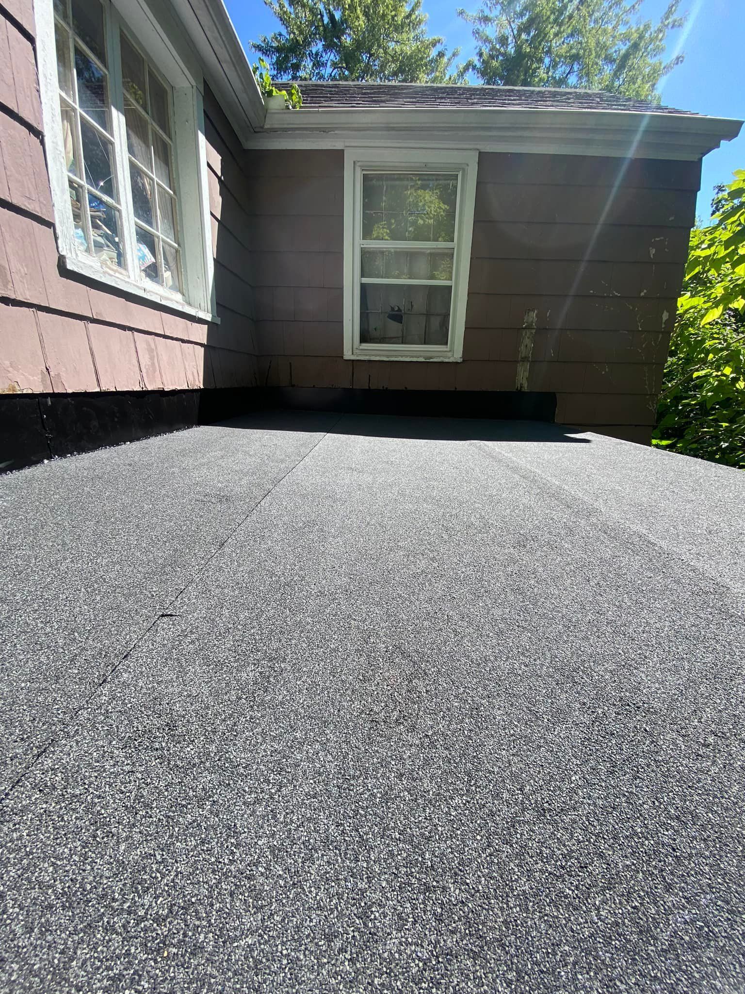 A house with a driveway and a window on the side of it.