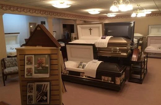 Interior of a funeral home displaying various open and closed coffins.