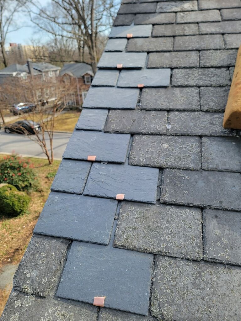 A close up of a roof with slate tiles on it.