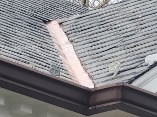A close up of a roof with a copper gutter.