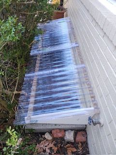 A clear plastic roof is sitting on the side of a brick building.