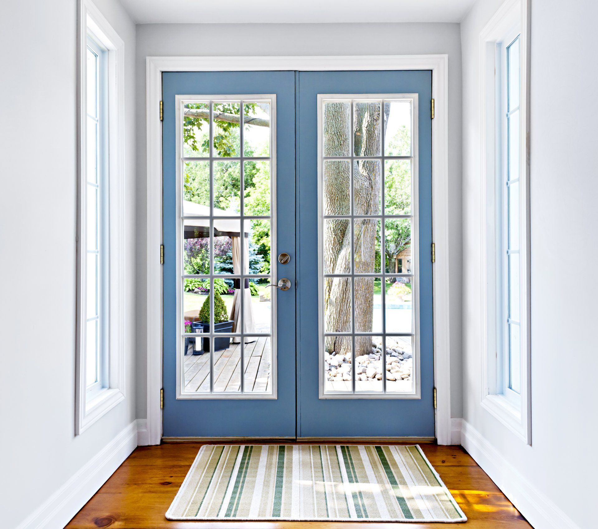 A hallway with a blue door and a rug on the floor