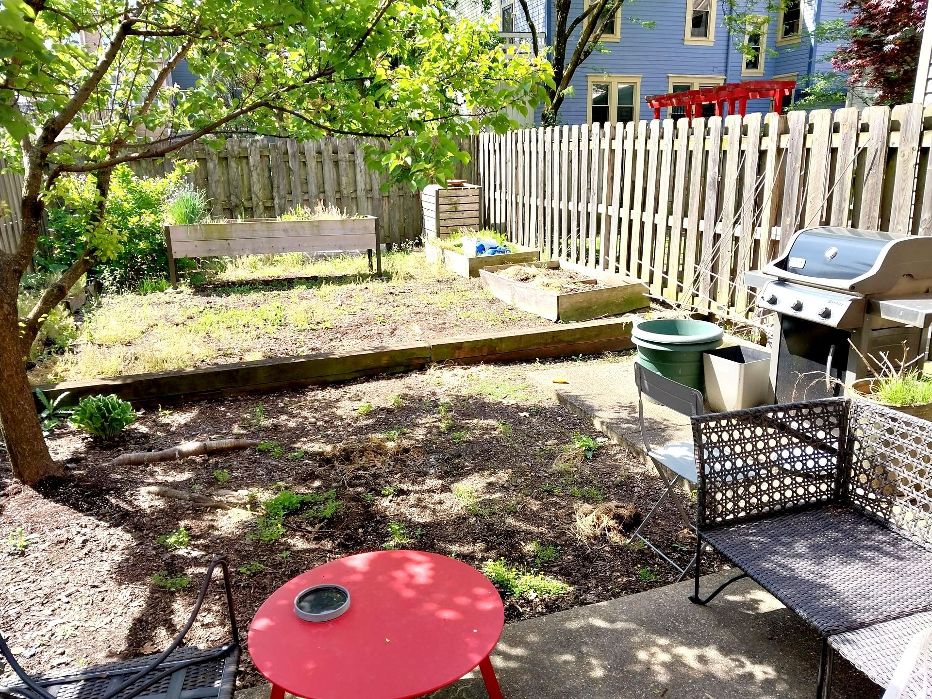 There is a red table and chairs in the backyard.