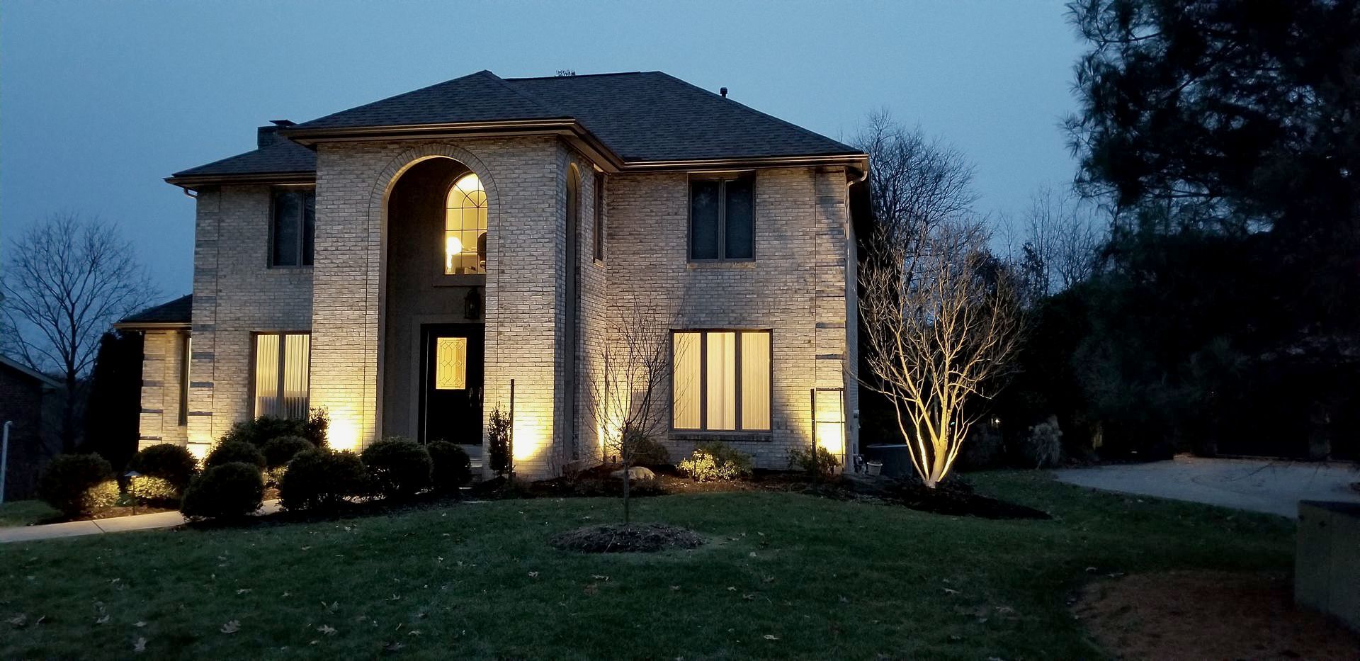 A large brick house is lit up at night