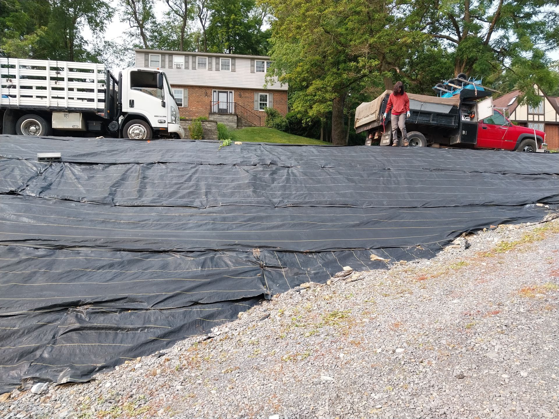 A truck is parked in a parking lot next to a house.
