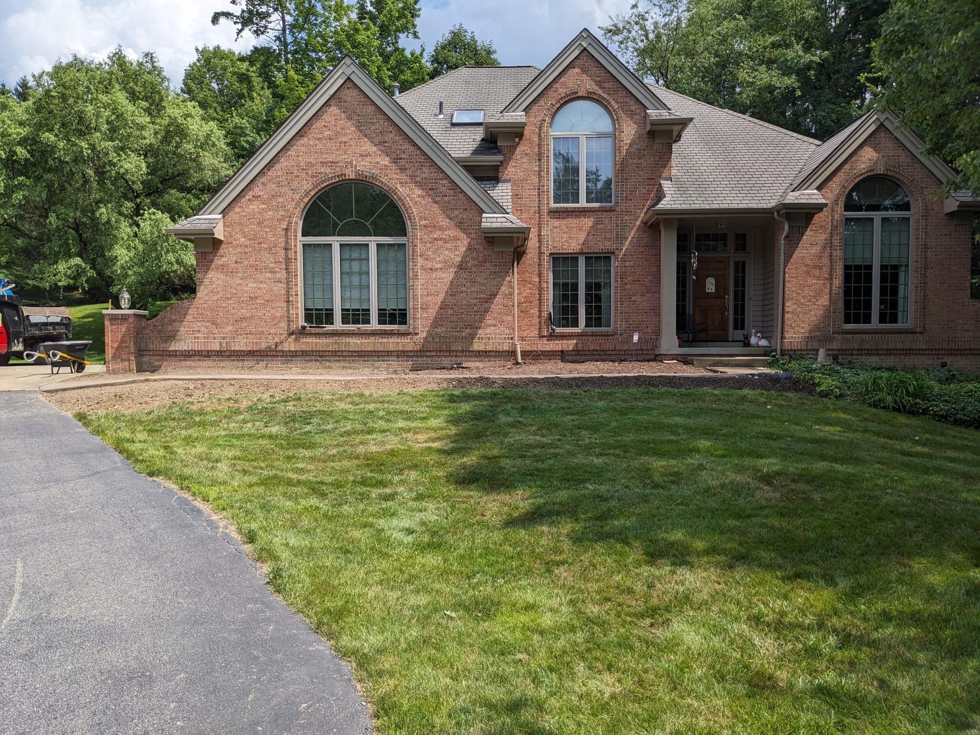 A large brick house with a lush green lawn in front of it