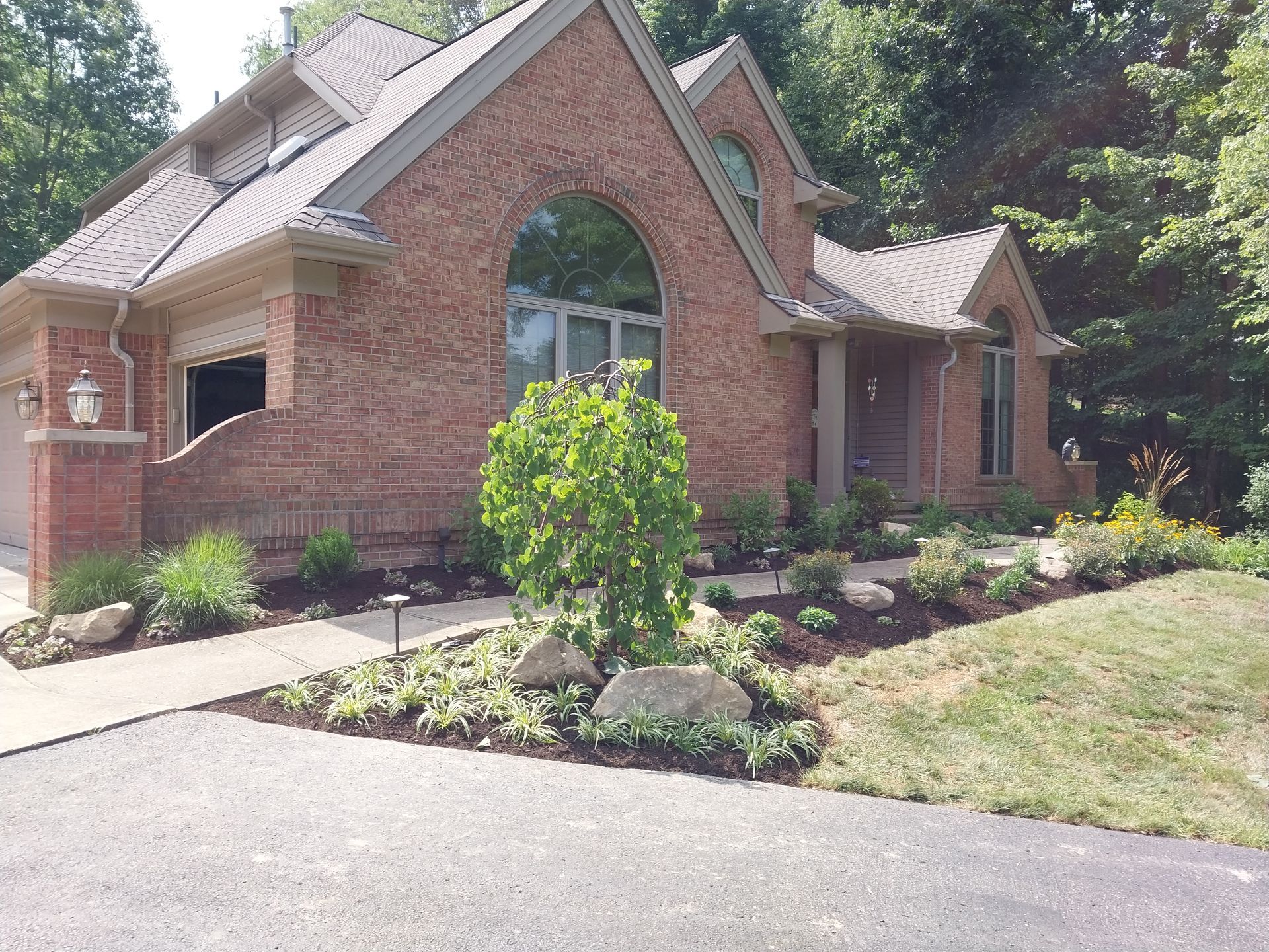 A large brick house with a lush green lawn in front of it