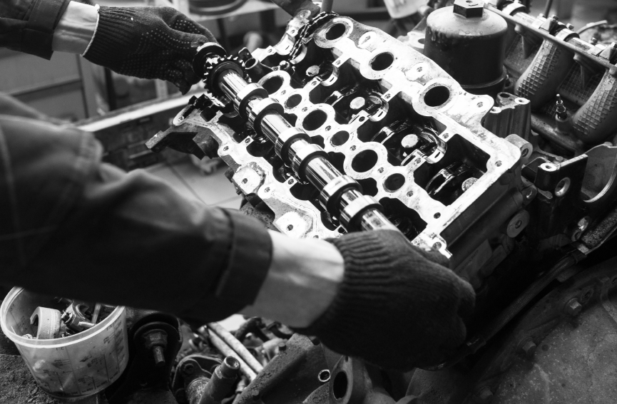 Hands in gloves assembling an engine, placing camshafts in the cylinder head. | Umphress Fleet Service LLC