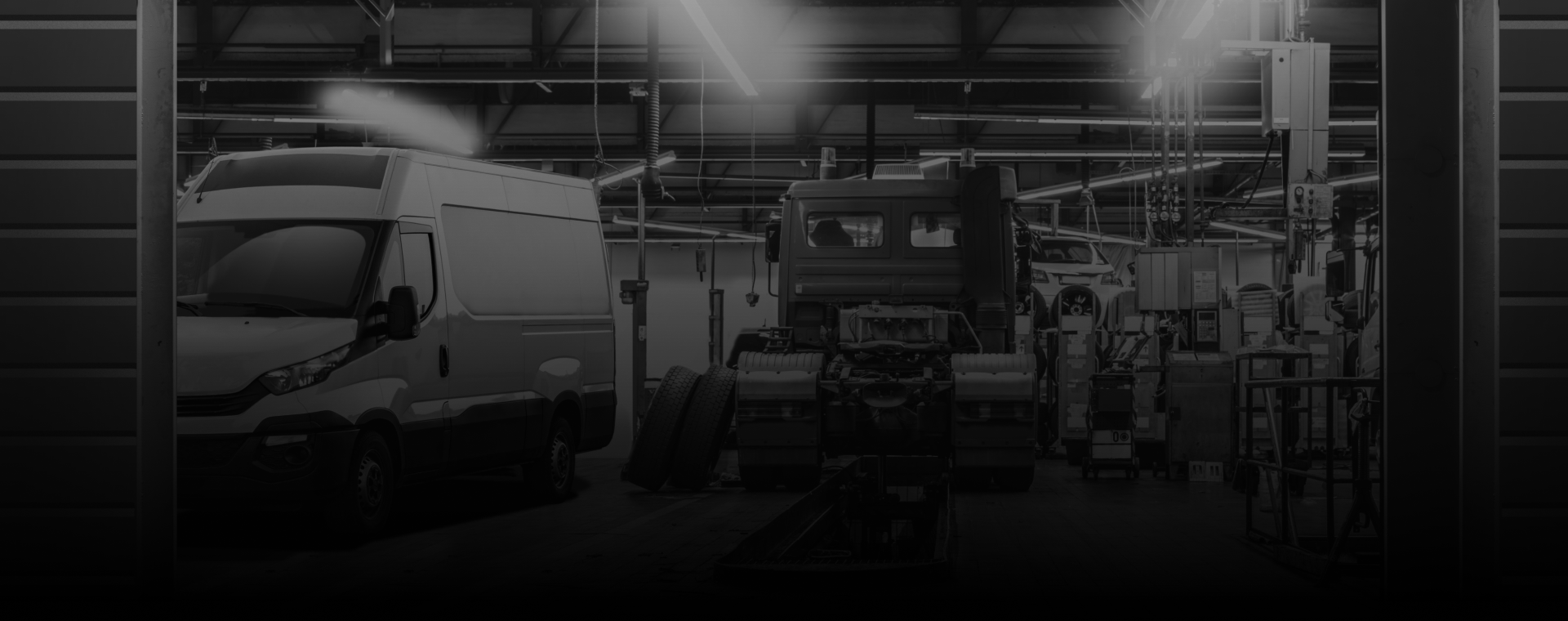 Inside a workshop: a van and truck are worked on under bright lights. | Umphress Fleet Service LLC