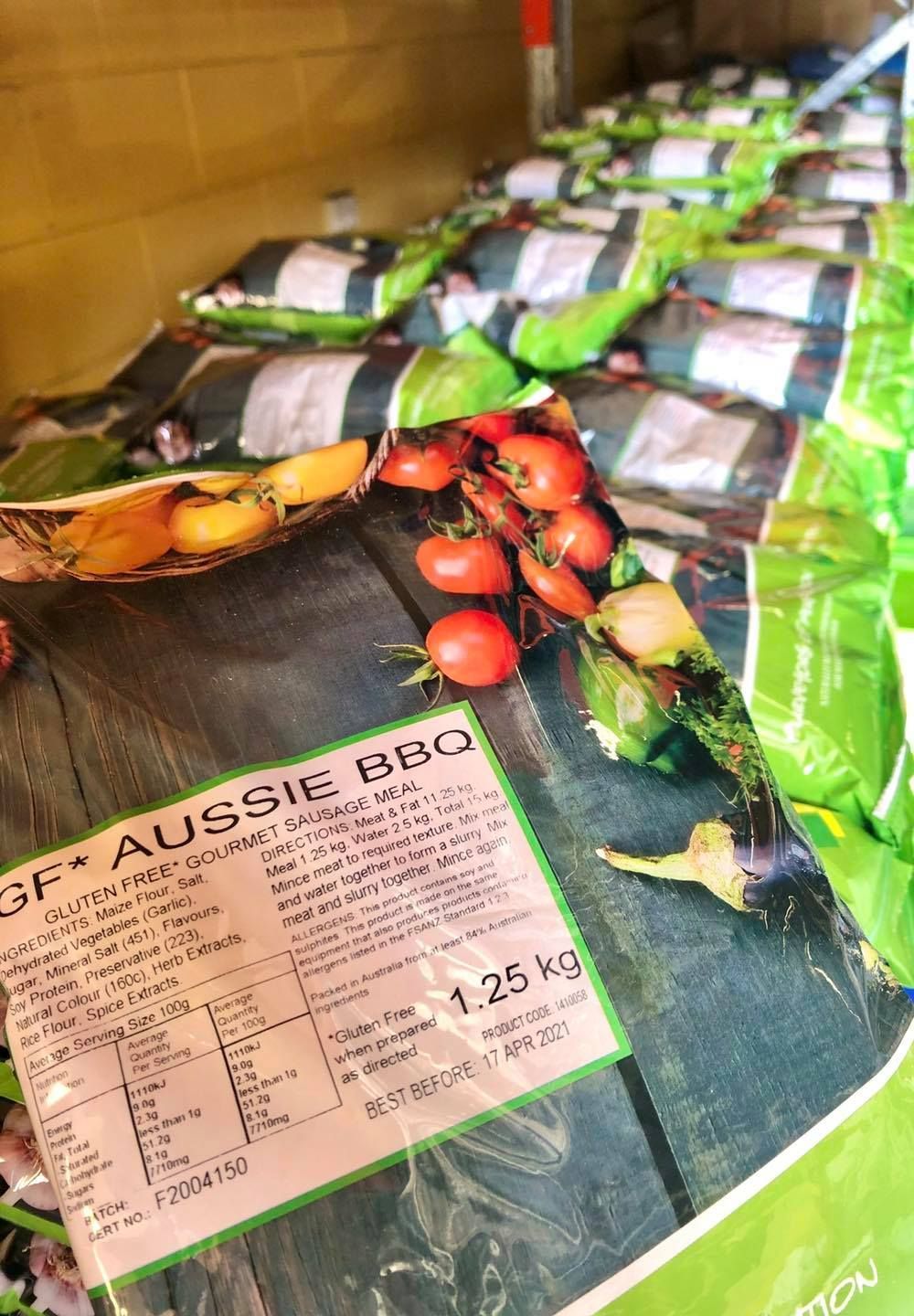 Bags of Aussie Bbq Charcoal With Scattered Tomatoes and Vegetables — CQ Butchers & Catering Supplies in Mackay, QLD