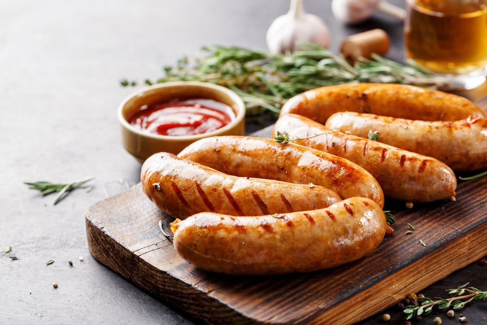 Grilled Sausages on a Wooden Board With Ketchup, Herbs, and Garlic — CQ Butchers & Catering Supplies in Proserpine, QLD