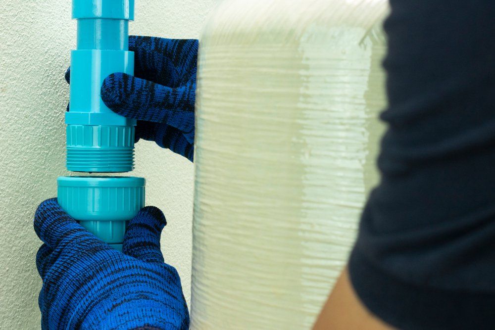 Plumber Connecting Union PVC At Storage Water Tank — Barney’s Tank Cleaning in Morisset, NSW