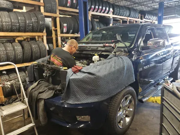 gallery mechanic at work in hood of truck | Precision Tires Auto