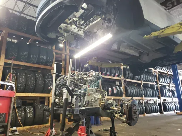 gallery white vehicle raised up repair in progress | Precision Tires Auto
