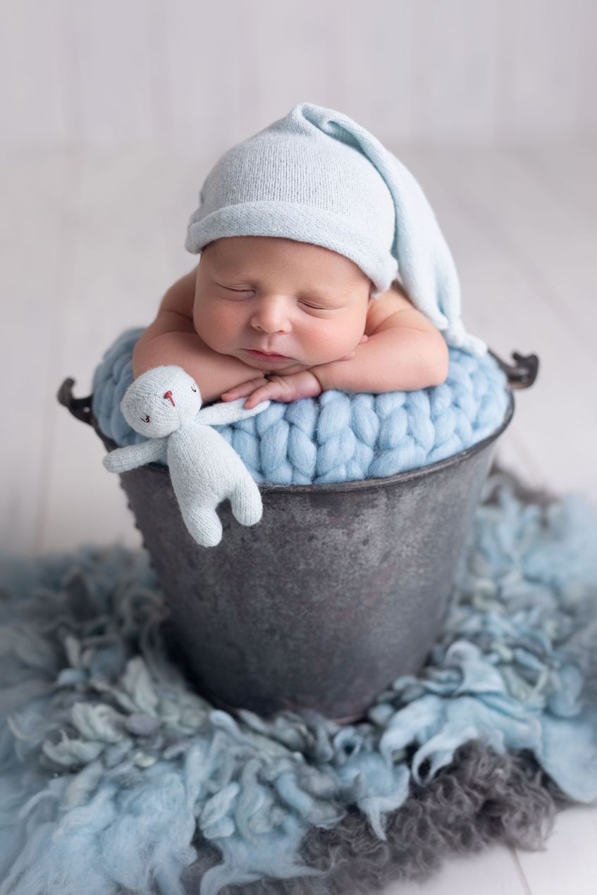 Baby wearing knit hat in a cozy basket