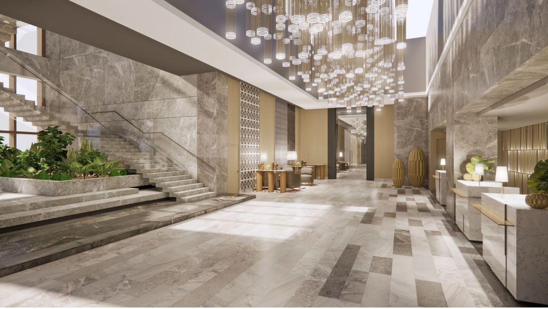 Luxurious hotel lobby with marble walls and floors, staircase with greenery, and ornate chandelier.