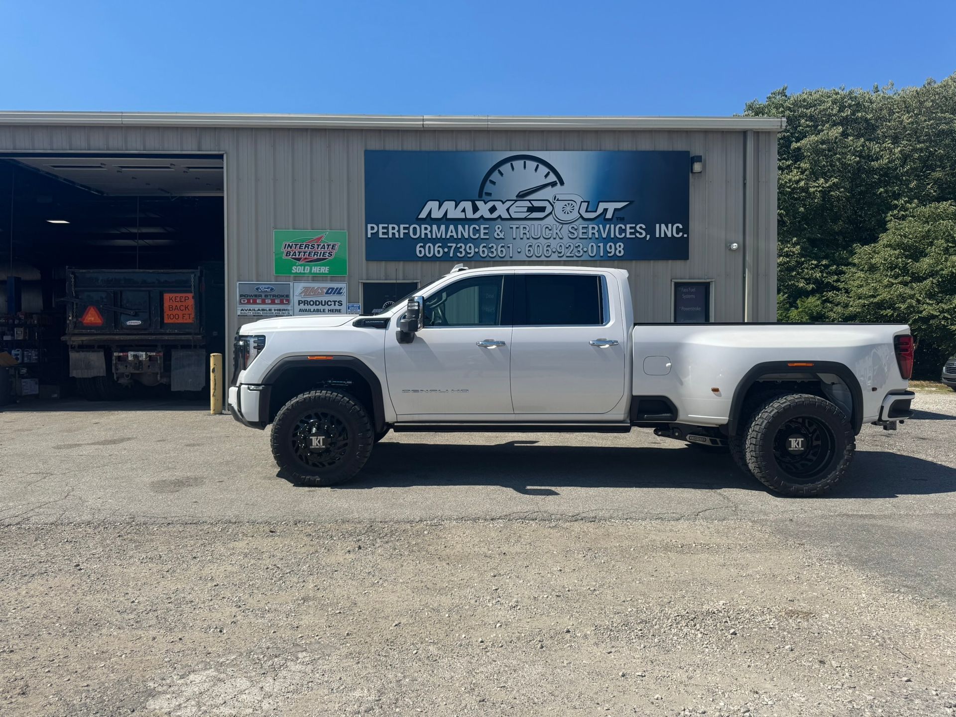 White truck parked in front of a building with a sign for MaxSpot, Inc.