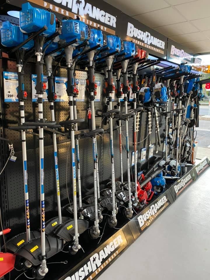 A bunch of bushranger lawn mowers are lined up in a store