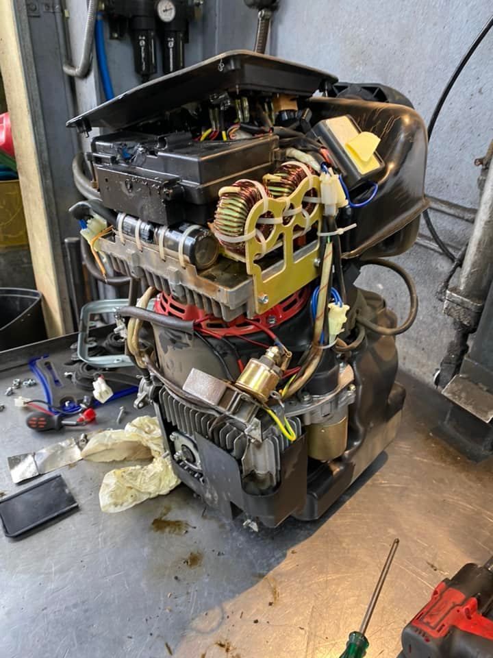 A broken engine is sitting on a table in a garage.
