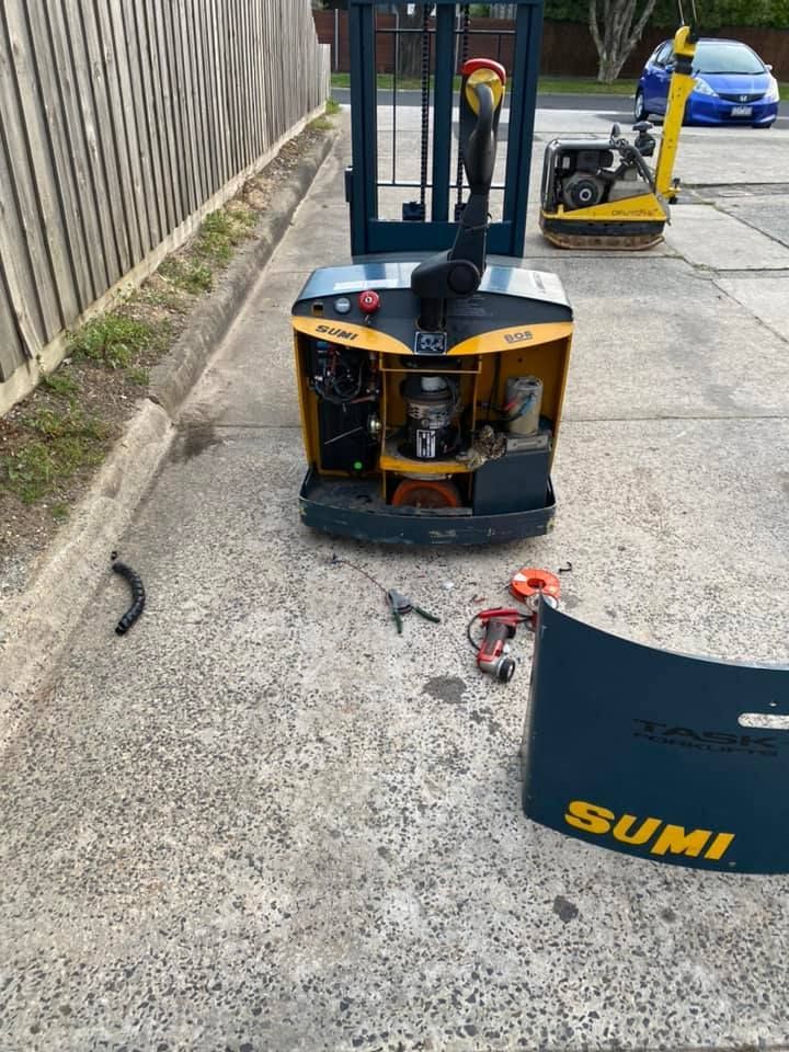 A forklift is sitting on the side of the road.