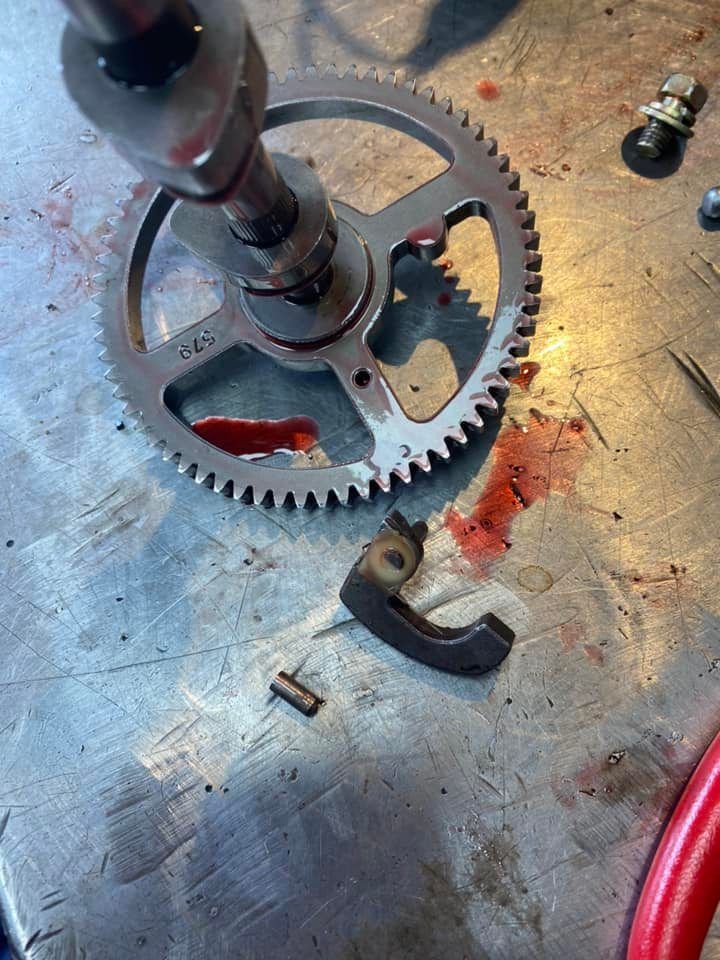 A broken gear is sitting on top of a metal table.