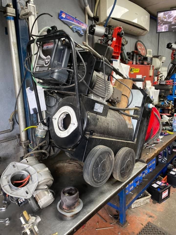 A machine is sitting on top of a table in a garage.