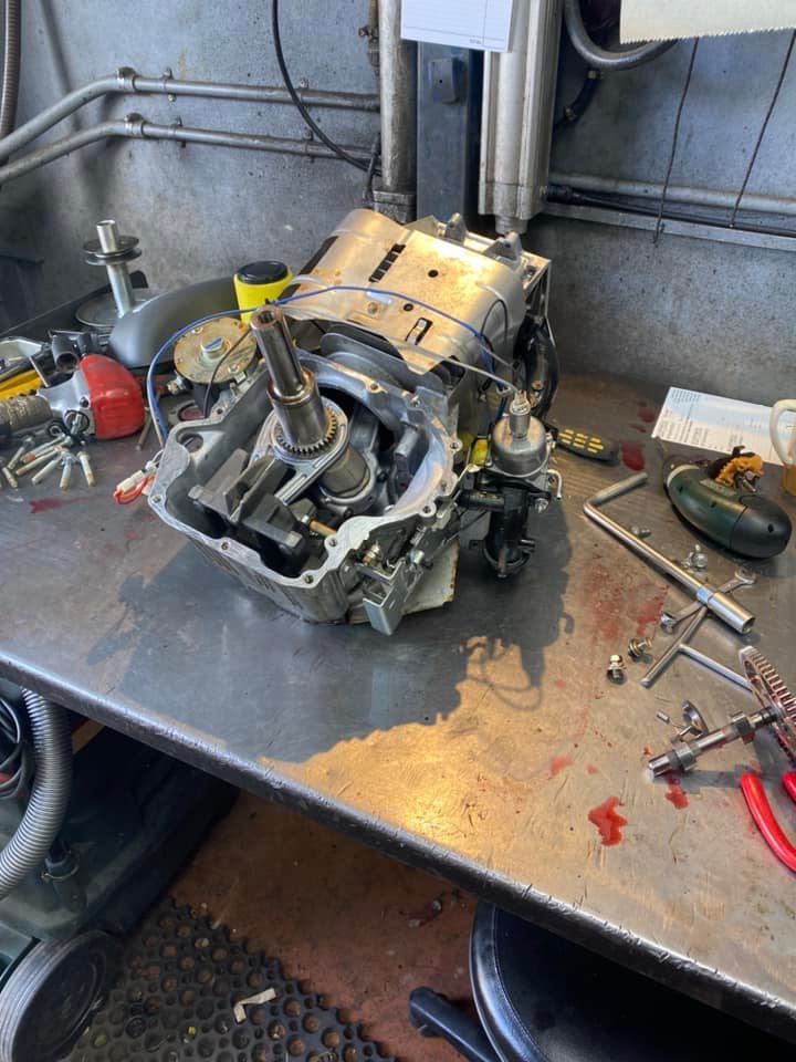 A broken engine is sitting on top of a metal table.