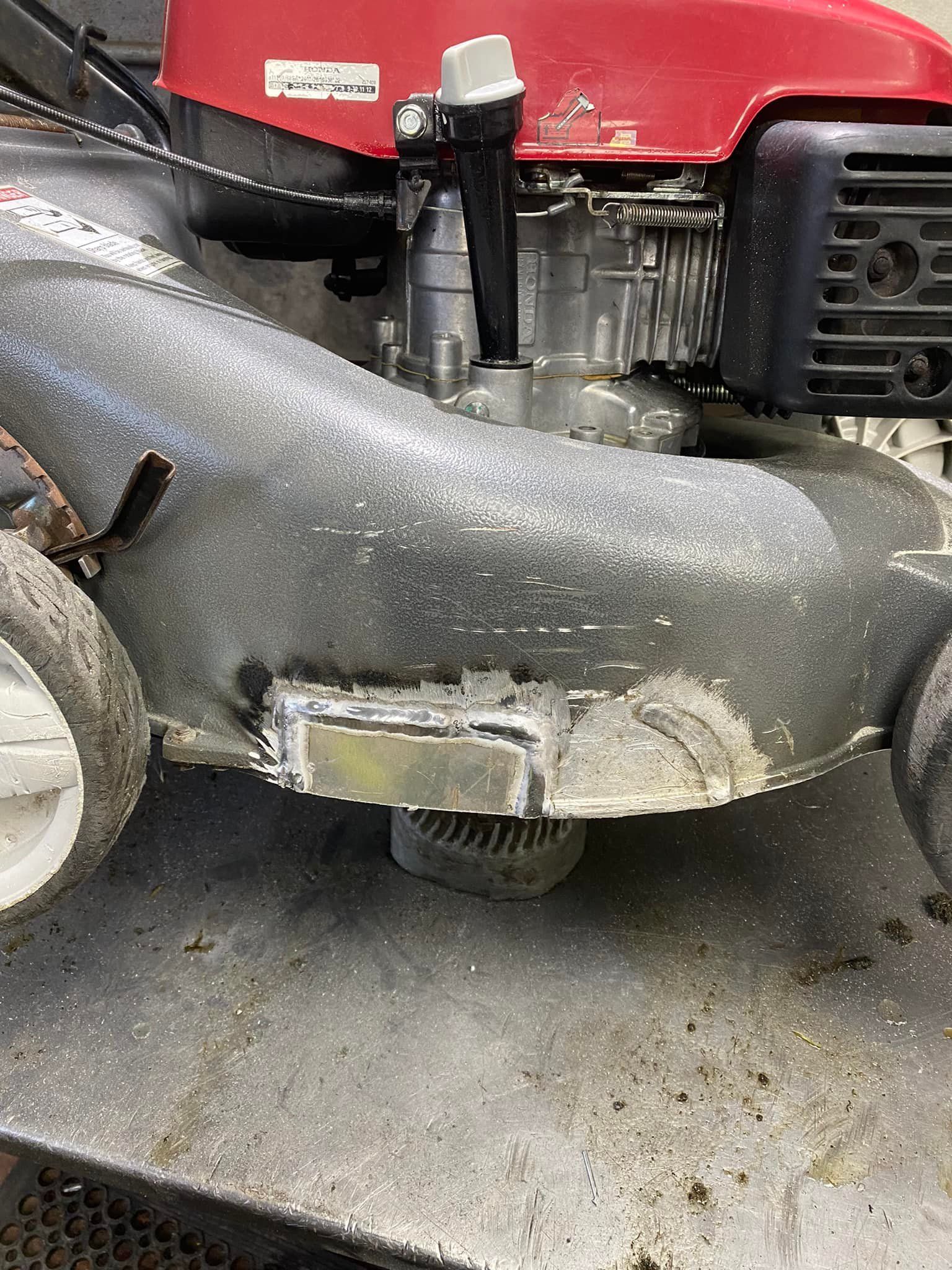 A lawn mower is sitting on top of a metal table.