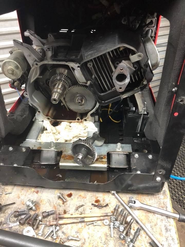 A lawn mower engine is being repaired on a table.