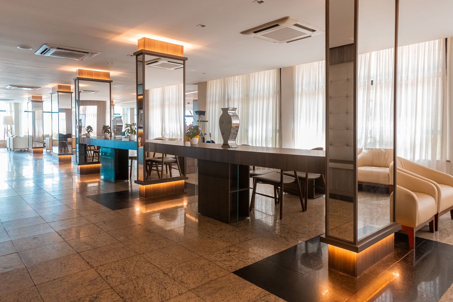 Um grande lobby de um hotel com uma mesa e cadeiras.