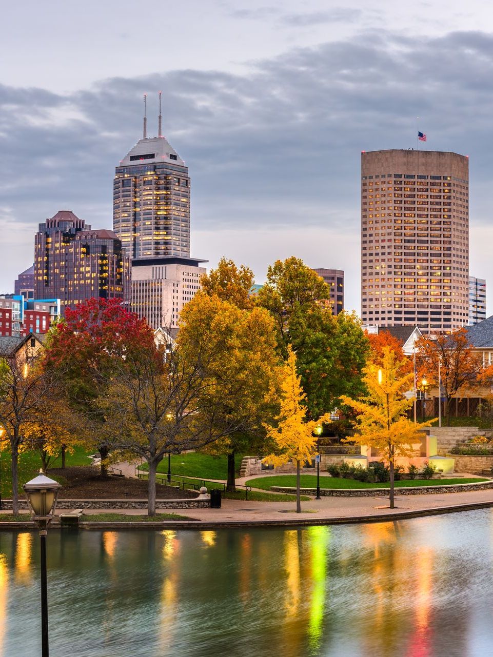 A wooden walkway leading to a gazebo overlooking a body of water at sunset.