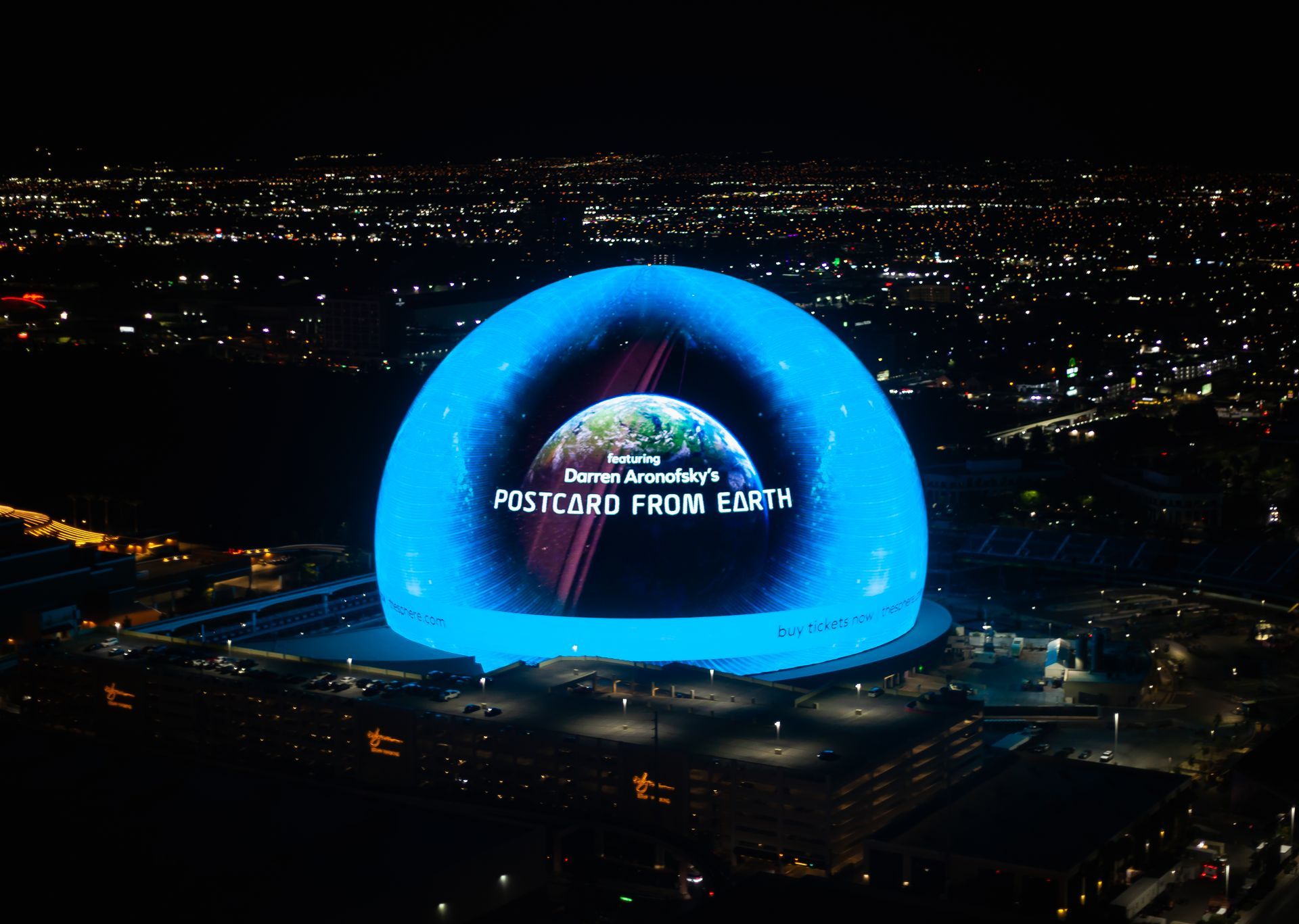 An aerial view of a dome that says postcard from earth. Sphere in Las Vegas. 