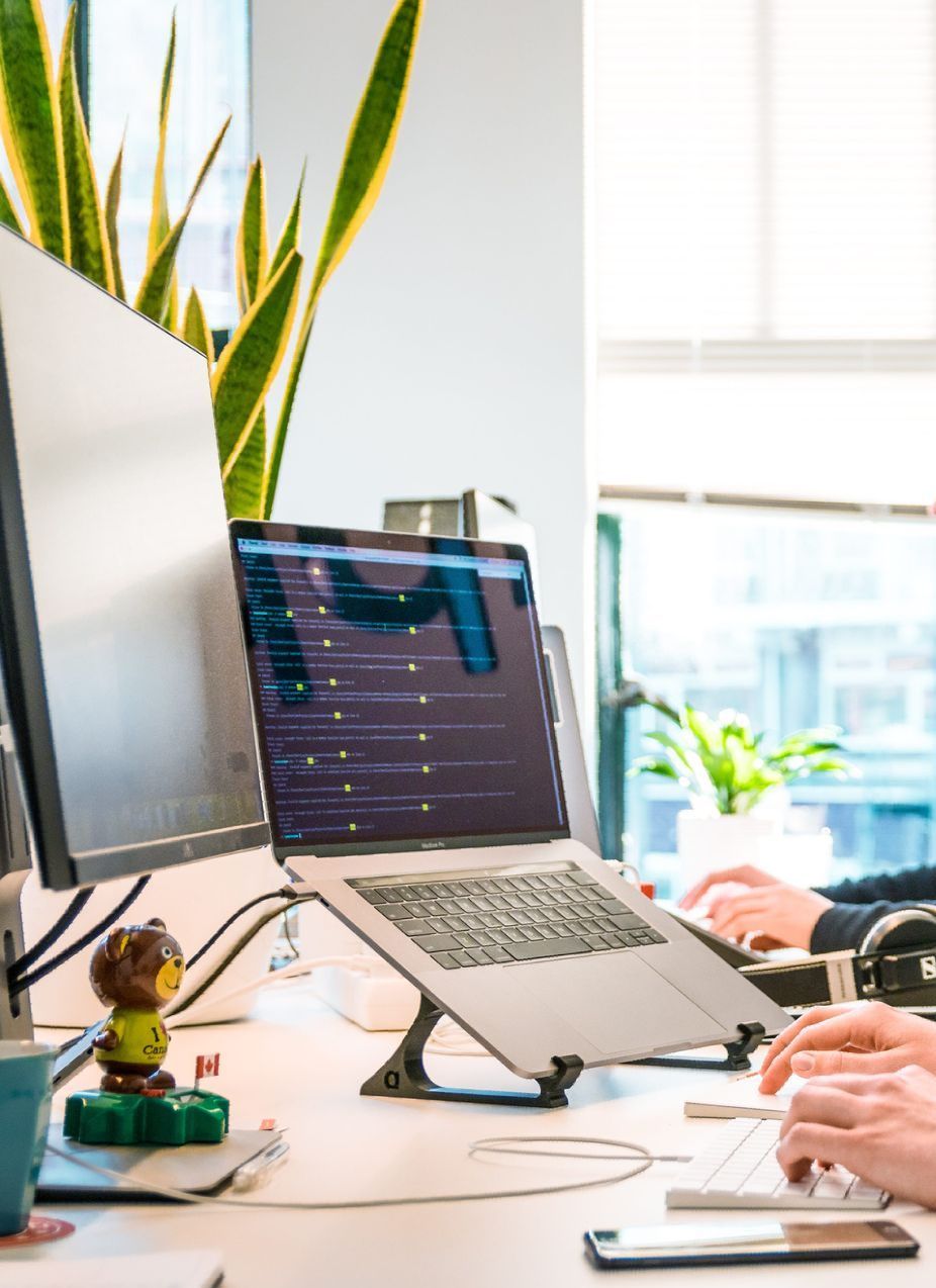 A person is sitting at a desk with a laptop and a monitor.