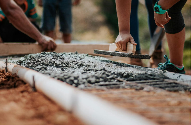 A group of concrete contractors is working on a sidewalk.