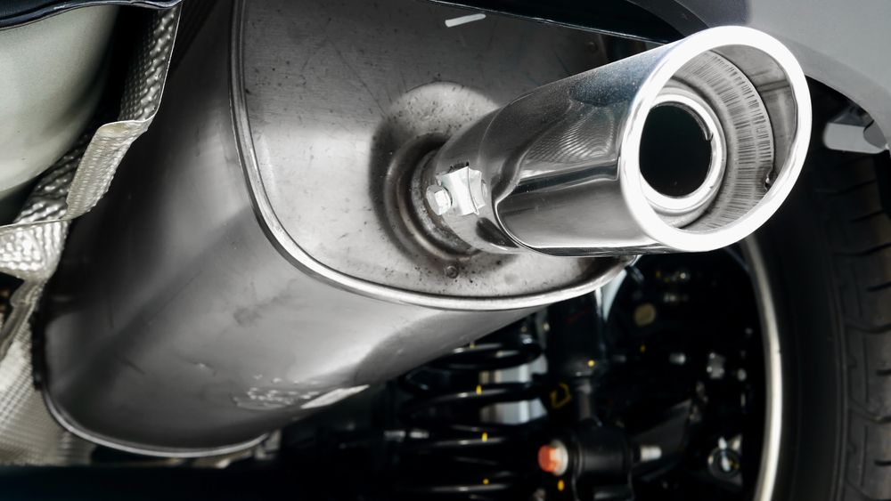 Close-up Of a Car’s Chrome Exhaust Pipe Beneath the Rear Bumper — Wingham Mechanical in Wingham, NSW