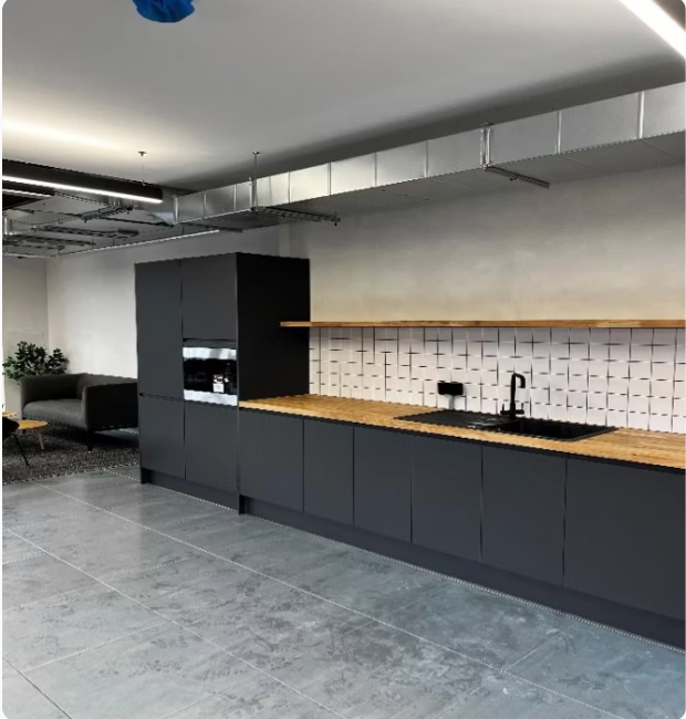 A kitchen with a sink and a bowl of fruit on the counter