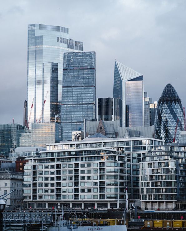 A city skyline with a lot of tall buildings and a bridge in the foreground.