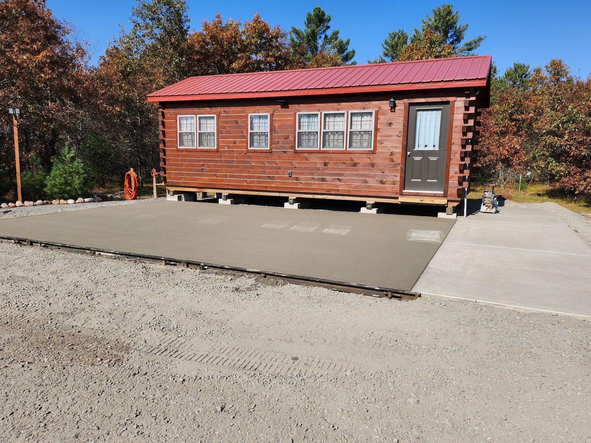A concrete driveway stretches between two rows of suburban houses and green lawns under an overcast sky.