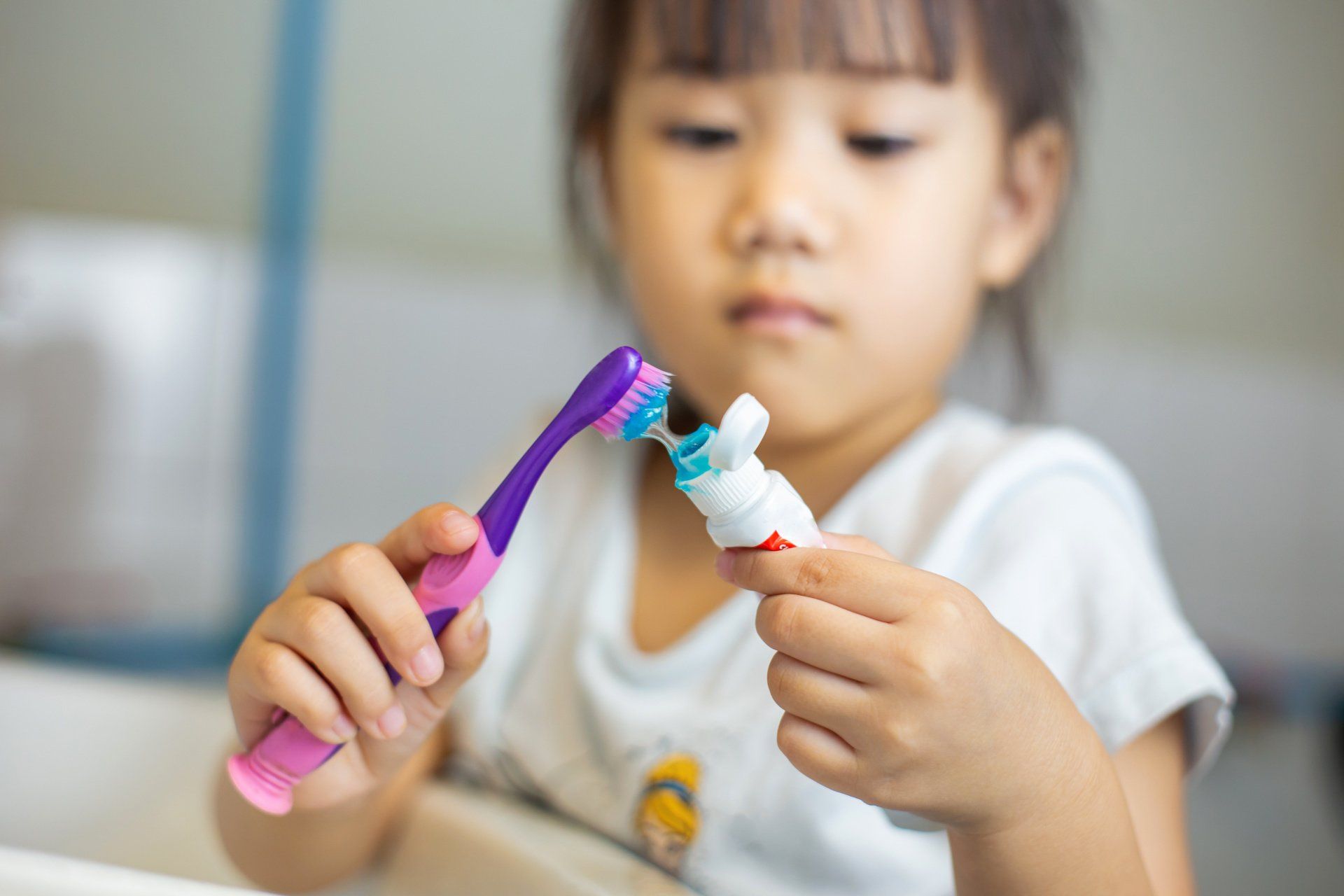 Little kid brushing teeth by herself.